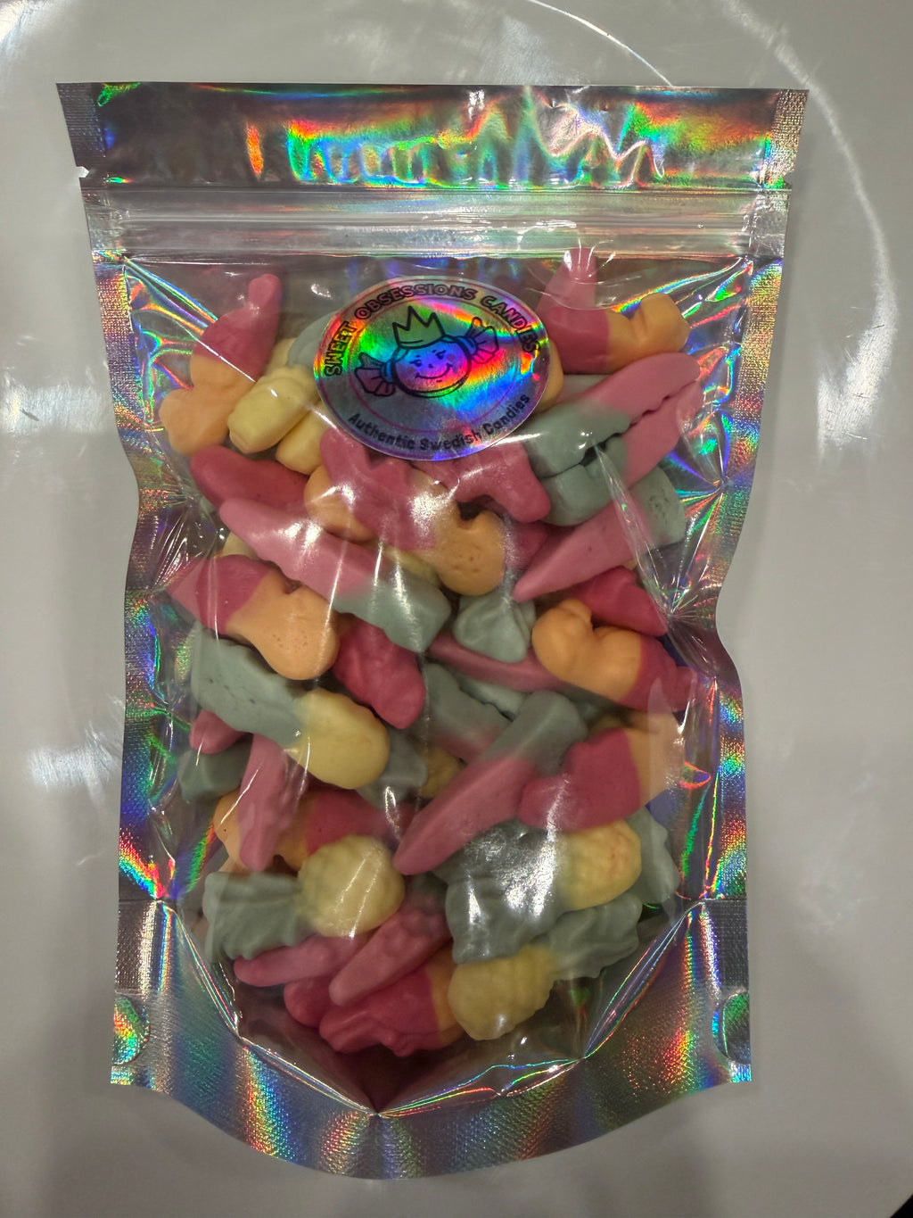 Resealable bag of Sweet Obsessions Squashies Tropical Fruit gummy candies in pink, orange, yellow, and green fruit shapes