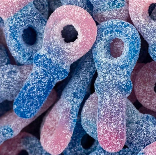 Extreme close-up of sugar-coated blue and pink pacifier-shaped gummy candies piled together, showing sparkly sugar-crystal texture.